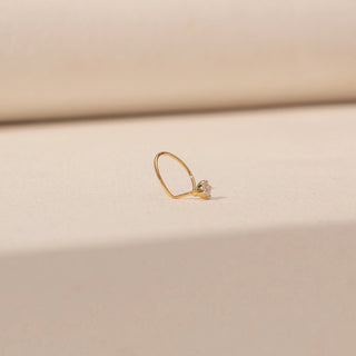 Angled view of Round Diamond Nosepin in 14KT Yellow Gold, featuring a round diamond cluster on a delicate open hoop.