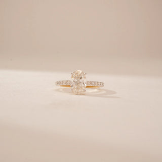 Close up view of a 14KT Yellow Gold diamond ring, featuring oval and pear-shaped diamonds with a diamond-set band.