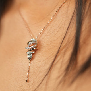 A side view of the neck of the model, wearing a pendant reveals a stunning 0.527-carat diamond with a spring lock of size 16 inches , set in 14 KT rose gold. The pendant features a blooming floral design, with the central diamond elegantly suspended, creating a captivating drop effect. The clean, white background accentuates the intricate craftsmanship and the lab-grown diamonds brilliant sparkle.