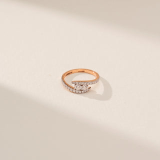 Top view of Elegant Crossover Curve Diamond Ring in 14KT Rose Gold, featuring round lab-grown diamonds on beige backdrop.