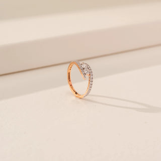 Angled view of Elegant Crossover Curve Diamond Ring in 14KT Rose Gold, featuring round lab-grown diamonds on a beige backdrop.
