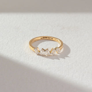 Top angled view of zigzag baguette diamond ring in yellow gold, featuring lab-grown baguette diamonds arranged in a sharp geometric pattern. Set against a soft beige textured background.