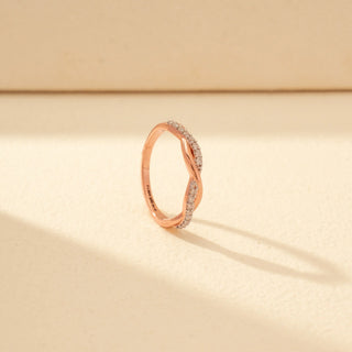 Angled view of Intertwined Diamond Ring in 14KT Rose Gold, featuring crossing bands with pavé-set diamonds.