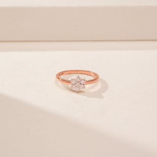 Close-up view of a 14KT Rose Gold diamond ring with a floral cluster of round diamonds on a plain band.