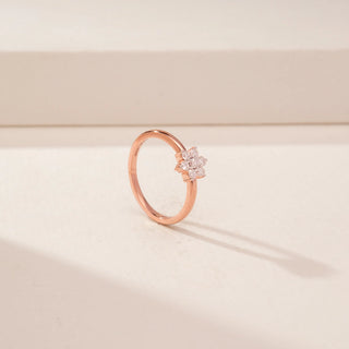 Angled view of a 14KT Rose Gold diamond ring with a floral cluster of round diamonds on a plain band.