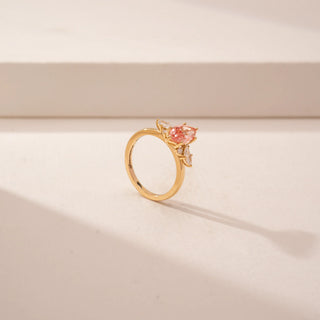 Angled view of a 14KT Yellow Gold diamond ring featuring a marquise-cut pink centre diamond.