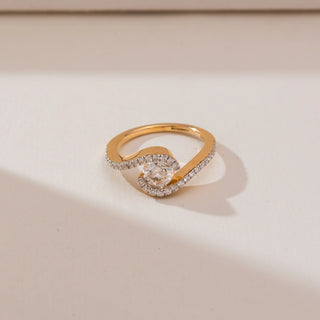 Top angled view of Swirling Wave Solitaire Diamond Ring in 14KT yellow gold, showcasing a round centre diamond framed by two curved pavé-set diamond bands.