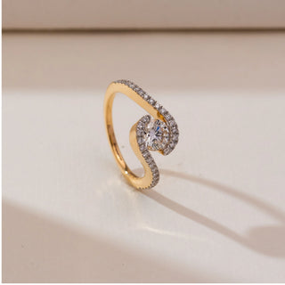 Side view of Swirling Wave Solitaire Diamond Ring in 14KT yellow gold, featuring a round centre diamond embraced by curved pavé-set diamond bands in a fluid wave design.