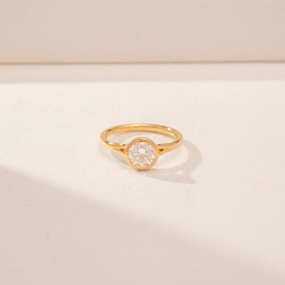 Front view of a 14KT Yellow Gold diamond ring with a round bezel-set diamond and slim polished band.
