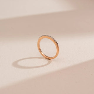 Side view of Reia’s 14 KT Rose Gold Minimal Everyday Ring, showing the slender band and pavé diamonds. Captured against a cream backdrop, the layout highlights the sleek, low-profile design.
