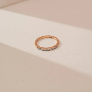 Top view of Reia’s 14 KT Rose Gold Minimal Rose Diamond Everyday Ring. Captured against a cream backdrop, the layout highlights the craftsmanship of the slender, linear design.