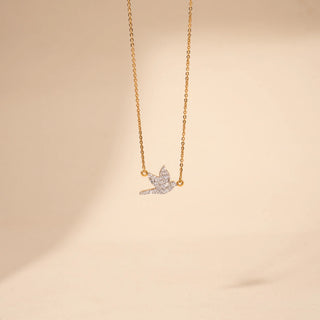 Front view of a round shaped  bird-inspired lab-grown diamond pendant necklace in 18 KT yellow gold, featuring a flying bird silhouette adorned with pavé-set round brilliant diamonds on a delicate cable chain.