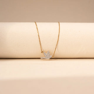 Close  up view of a round shaped  bird-inspired lab-grown diamond pendant necklace in 18 KT white gold, featuring a flying bird silhouette adorned with pavé-set round brilliant diamonds on a delicate cable chain.