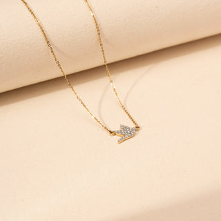 Angled view of a round shaped  bird-inspired lab-grown diamond pendant necklace in 18 KT rose gold, featuring a flying bird silhouette adorned with pavé-set round brilliant diamonds on a delicate cable chain.