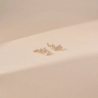Angled view of floral diamond earrings in 14KT yellow gold, featuring clustered round lab-grown diamonds in a delicate vine design.