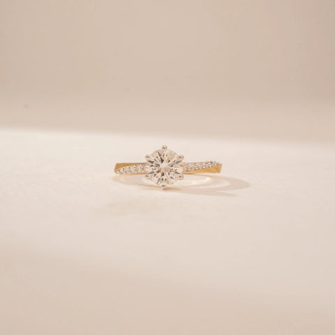 Front view of a 14KT Yellow Gold diamond ring, featuring a round centre diamond and diamond-set shoulders.