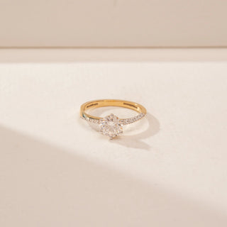 Top view of a 14KT Yellow Gold diamond ring, featuring a round centre diamond and diamond-set shoulders.