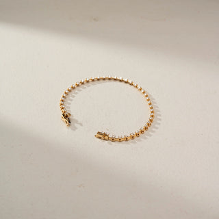 Top view of a lab-grown diamond tennis bracelet in 14 KT yellow gold, featuring a continuous row of round brilliant diamonds with a secure box clasp and timeless design.