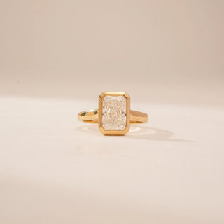 Front view of a 14KT Yellow Gold diamond ring, featuring a rectangular step-cut centre diamond in a bezel setting.
