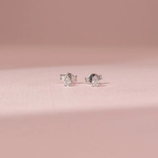 Front view of a 14KT White Gold diamond earrings with pear-shaped diamonds in secure stud settings.