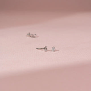 Angled view of a 14KT White Gold diamond earrings with pear-shaped diamonds in secure stud settings.