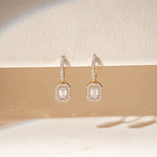 Front view of 14KT Yellow Gold diamond drop earrings with emerald-cut centre stones, pavé halos and diamond-set huggie hoops.