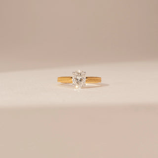 Front view of a 14KT Yellow Gold diamond ring with an oval centre diamond and textured braided shoulders.