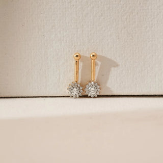 Front view of yellow gold floral sunburst diamond koppu featuring a clustered round lab-grown diamond bloom with an elongated gold stem design, displayed on a soft neutral textured surface.