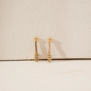 Side view of yellow gold floral diamond koppu showing layered sunburst setting with clustered round lab-grown diamonds and polished gold stem, displayed on a soft neutral surface.