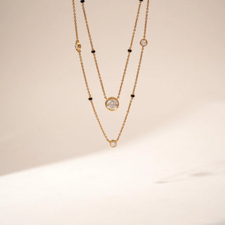 Front view of 14KT Yellow Gold layered diamond  mangalsutra featuring bezel-set round diamonds and black bead accents.
