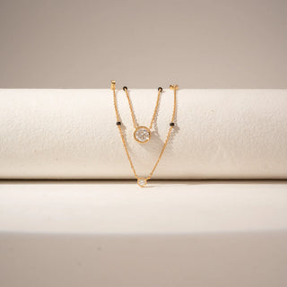 Close-up view of 14KT Yellow Gold layered diamond mangalsutra
featuring bezel-set round diamonds and black bead accents.