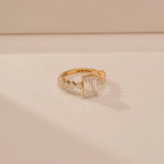 Side view of a 14KT Yellow Gold diamond ring, featuring a rectangular step-cut centre diamond and diamond-set shoulders.