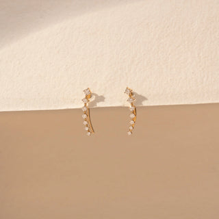 Angled view of Curved Drop Diamond Earrings in 14KT Yellow Gold, featuring round diamonds in a graceful cascading design.