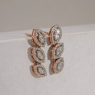 Triple Marquise Diamond Drop Earrings in 14KT hallmarked rose gold, shown at an angled side view. The earrings feature three linked marquise-shaped diamond clusters, each surrounded by pavé diamonds. Diamonds are EF colour, VVS clarity, weighing 1.21 carats in total, with a 4.12-gram product weight.