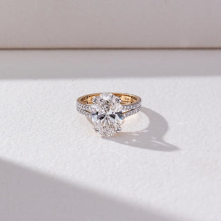 Top view of Oval Solitaire Diamond Ring in 14KT Yellow Gold, featuring a centred oval lab grown diamond with a double pavé-set band. Set on a beige backdrop, the design highlights symmetry and brilliance.

