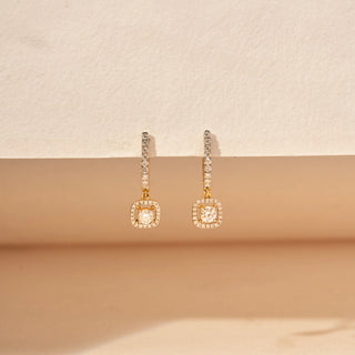 Front view of round-cut lab-grown diamond drop earrings in 14 KT yellow gold, featuring pavé-set diamond bar drops with cushion-shaped diamond halo charms and cushion-cut centre diamonds in an elegant design.
