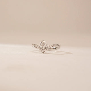 Angled view of a 14KT White Gold diamond ring, featuring an oval centre diamond and a V-shaped diamond-set band.