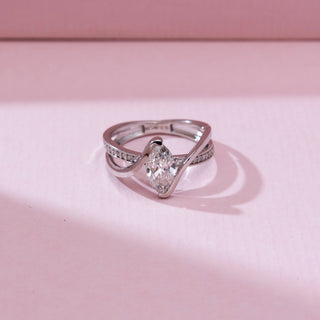 Top view of 14KT white gold bypass ring featuring a marquise-cut centre diamond and a flowing double band, one pavé-set with shimmering round diamonds.