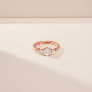 Top view of a 14KT Rose Gold diamond ring with a round centre diamond and tapered side diamonds.