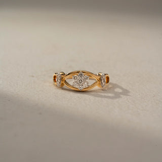 Front view of a floral diamond ring in 14 KT Yellow Gold, featuring a cluster of round lab-grown diamonds nestled within an eye-shaped openwork motif and accented by marquise-cut side diamonds, displayed against a beige backdrop.