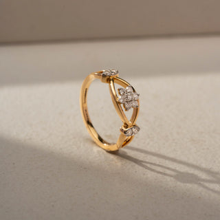 Angled view of a floral diamond ring in 14 KT Yellow Gold, featuring a cluster of round lab-grown diamonds nestled within an eye-shaped openwork motif and accented by marquise-cut side diamonds, displayed against a beige backdrop.