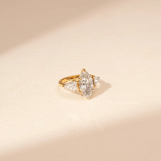 Side view of a 14KT Yellow Gold diamond ring with a marquise centre diamond, pear-shaped side diamonds and baguette accents.