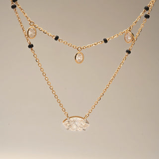 Close up view of two Diamond Mangalsutra designs in 14KT Yellow Gold — one featuring bezel-set oval diamond drops on a black bead chain, and another with a bold marquise solitaire pendant. Captured against a beige backdrop.