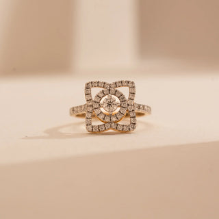 Front view of Reia’s 14 KT Yellow Gold Geometric Square Halo Diamond Ring. The layout highlights the structured square halo and pavé-set shimmering band, captured on a clean, cream backdrop.