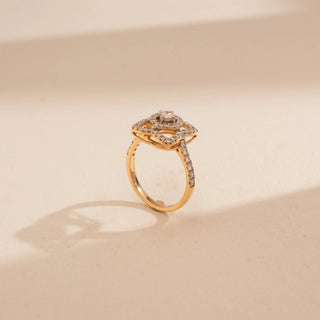 Top-down view of Reia’s 14 KT Yellow Gold Geometric Square Halo Diamond Ring. It highlights the structured square halo and shimmering pavé-set band on a cream backdrop.