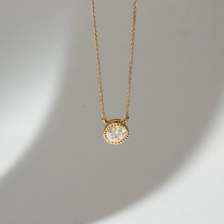 Top view of Round Bezel Diamond Pendant Necklace in 14KT Yellow Gold, featuring a centred round lab grown diamond in a textured bezel setting. Set on a neutral backdrop, the design highlights brilliance and refined sparkle.
