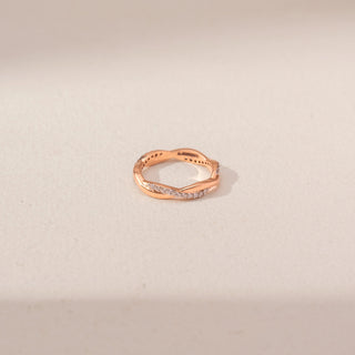 Top view of an intertwined diamond ring in 14KT rose gold, featuring pavé-set diamonds and a graceful crossover design.