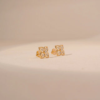 Angled view of 14KT yellow gold floral diamond stud earrings, featuring four-petal motifs with round lab-grown diamonds.