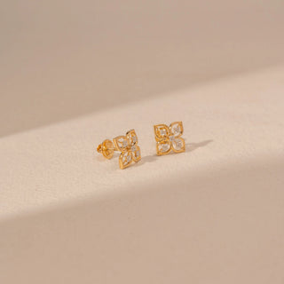 Close up Angled view of 14KT yellow gold floral diamond stud earrings, featuring four-petal motifs with round lab-grown diamonds.