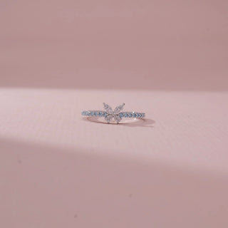 Front view of a 14KT White Gold diamond ring featuring a butterfly motif with marquise diamonds and blue diamond accents.
